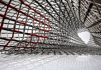 Abstract Metal Mesh Sculpture with Red Accents and Reflection