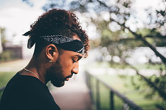 Young man with bandana and cross earring in profile