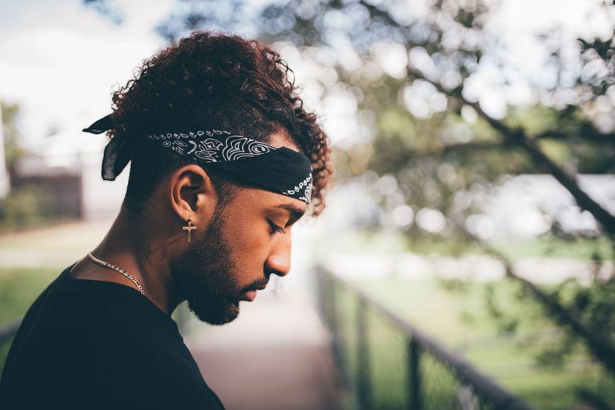 Young man with bandana and cross earring in profile