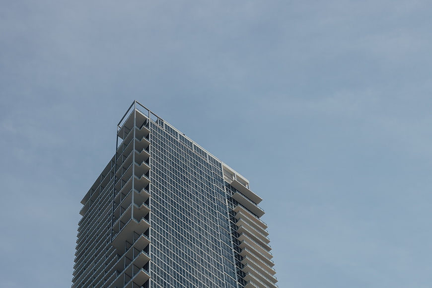 Low angle view of modern skyscraper against blue sky