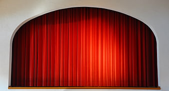 Red theater curtain in arched stage opening