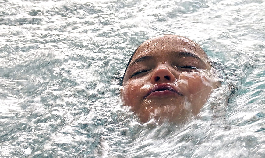 Close-up of a child's face floating in a swimming pool