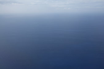 Minimalist Blue Ocean Horizon with Soft Clouds