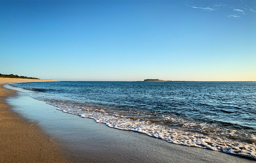Serene Beach Landscape with Gentle Waves and Distant Island