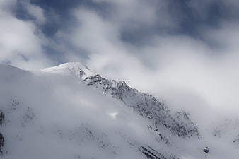 Snowy Mountain Peak Through Clouds