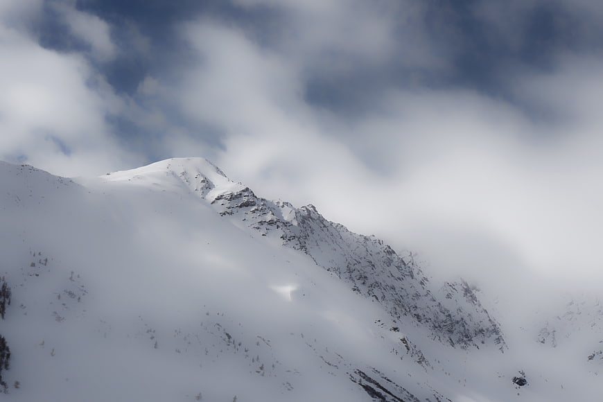 Snowy Mountain Peak Through Clouds