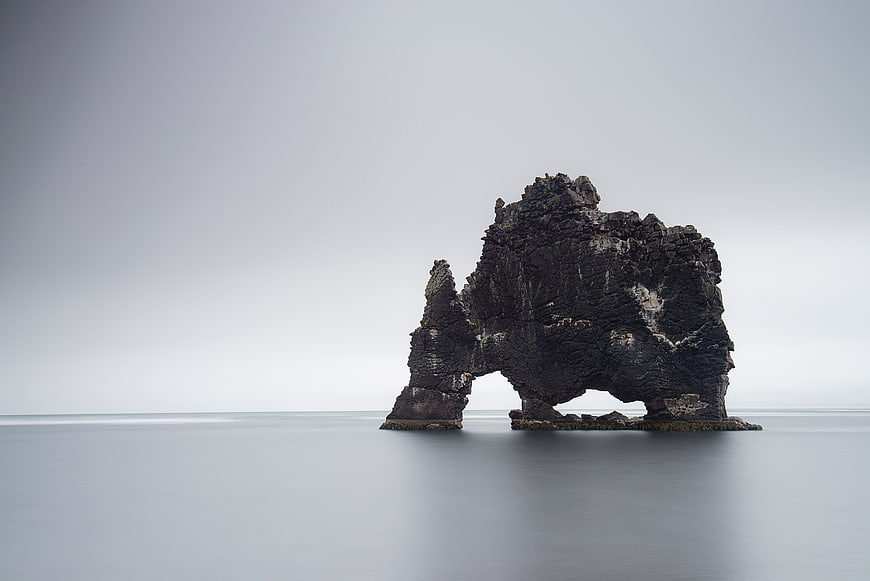 Minimalist Long Exposure of Dark Rock Formation in Ocean