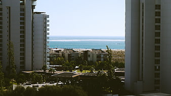 High-rise buildings framing a sunny beach and ocean view