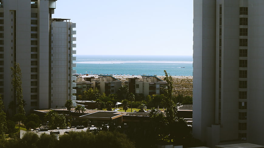 High-rise buildings framing a sunny beach and ocean view