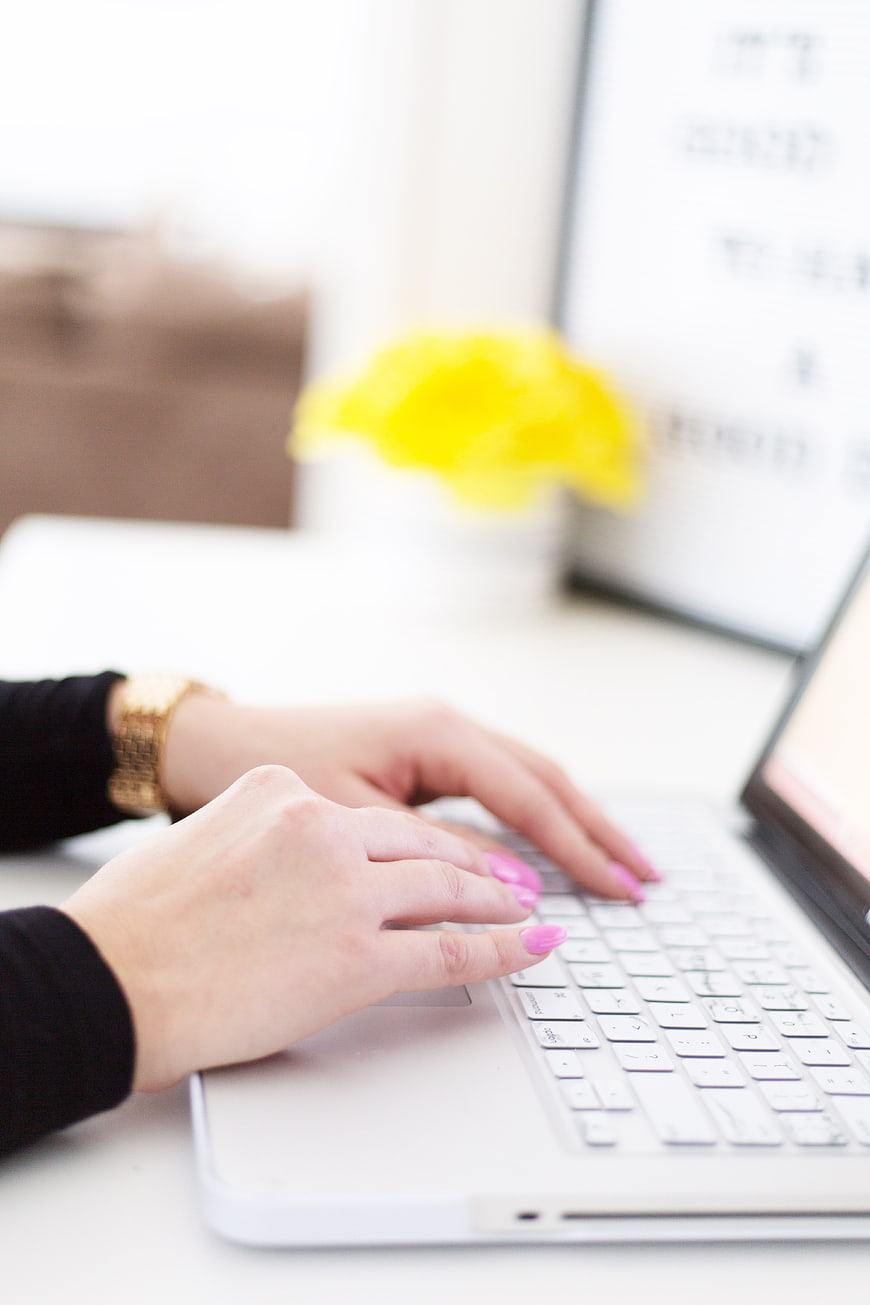 Woman Typing on Laptop with Pink Nails