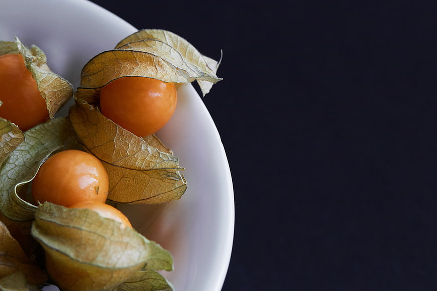 Fresh Physalis Berries in White Bowl on Dark Background