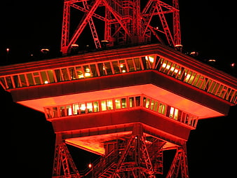 Red illuminated steel tower structure at night