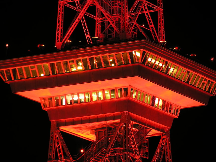 Red illuminated steel tower structure at night