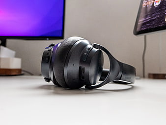 Black Headphones on Desk with Blurred Monitor Background