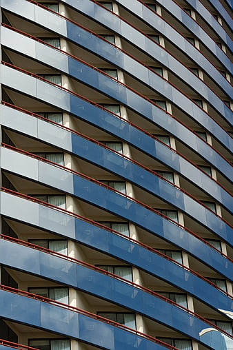 Modern blue glass apartment building facade with red railings