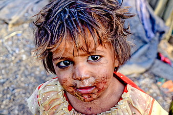 Close-up portrait of young girl with dirty face in slums