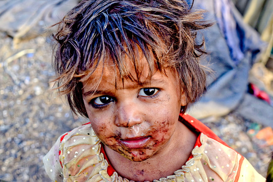 Close-up portrait of young girl with dirty face in slums