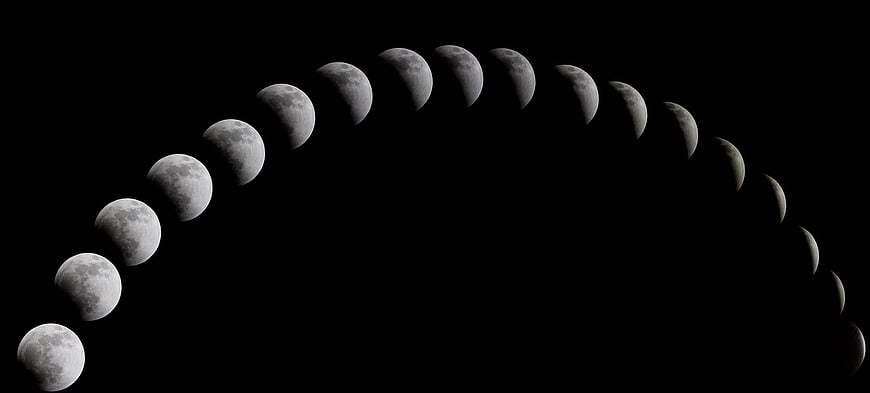 Composite sequence of lunar eclipse phases against black sky