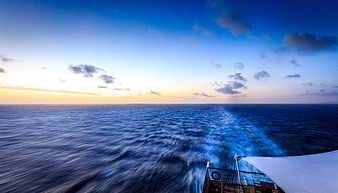 Boat Wake on Ocean at Sunset with Blue Sky