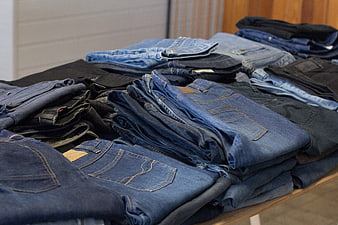 Stacks of folded vintage denim jeans in a thrift store