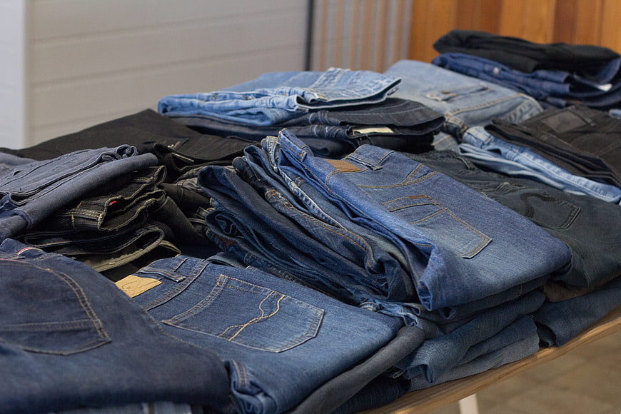 Stacks of folded vintage denim jeans in a thrift store