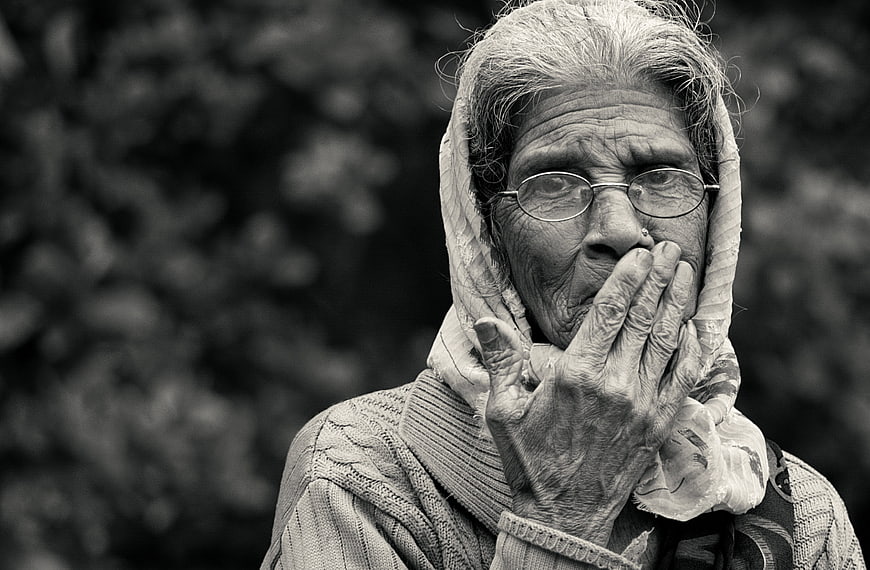 Black and white portrait of an elderly woman with hand over mouth