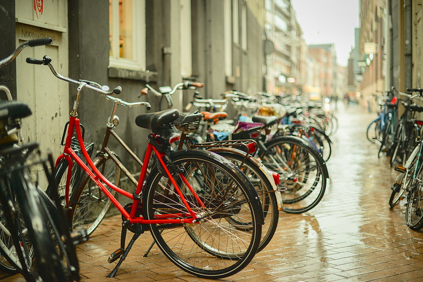 Red Bicycle Parked on Wet Cobblestone Street in European City