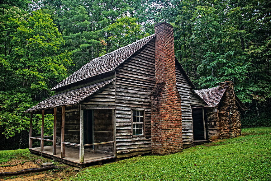 Historic Rustic Log Cabin With Brick Chimney In Lush Forest