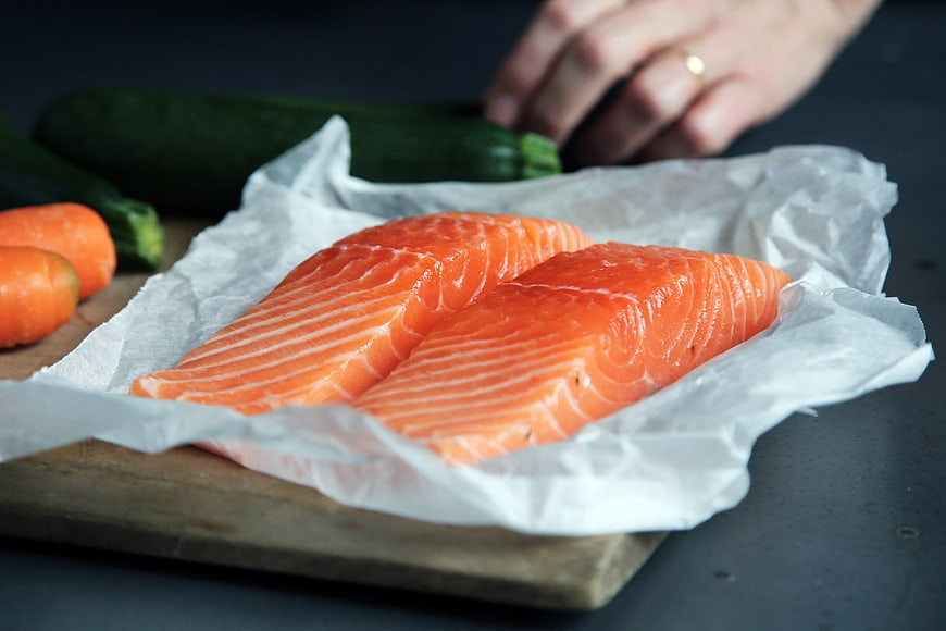 Fresh Raw Salmon Fillets on Wooden Board with Vegetables