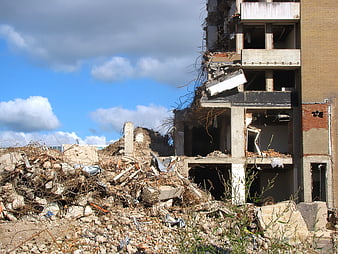 Demolished building with rubble and debris under blue sky
