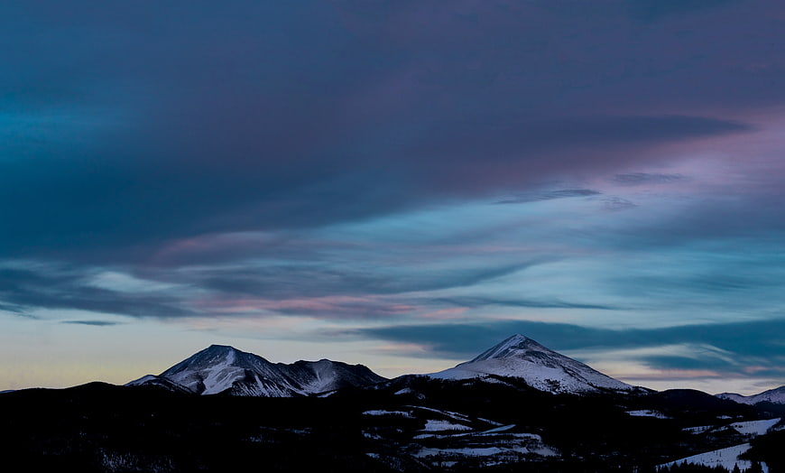 Snowy Mountain Peaks Under Dramatic Blue and Purple Twilight Sky