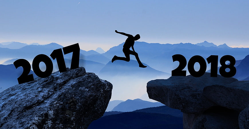 Silhouette of man jumping between 2017 and 2018 on mountain rocks