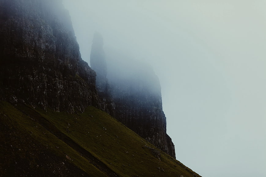 Misty Mountain Cliff with Green Grass Slope