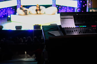 Audio mixing console on stage with blurred background