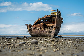 Rusty Abandoned Shipwreck on Rocky Beach Shore