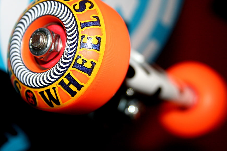 Close-up of orange skateboard wheel with text detail