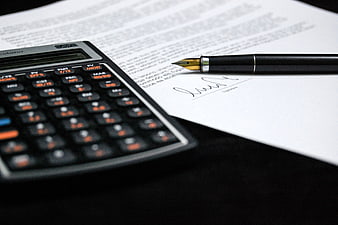 Signed contract with fountain pen and financial calculator