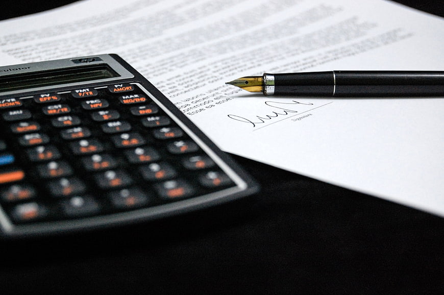 Signed contract with fountain pen and financial calculator