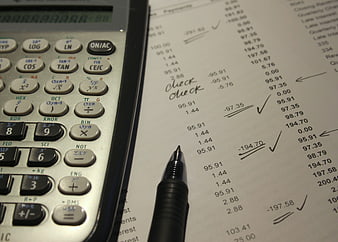Calculator and pen on financial document with calculations