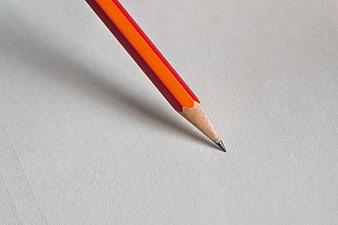 Close-up of orange pencil tip on white paper