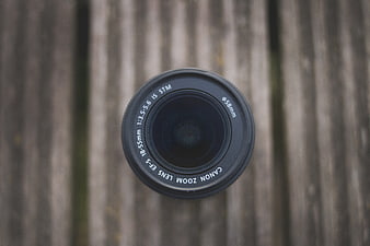 Overhead view of Canon camera lens on wooden background