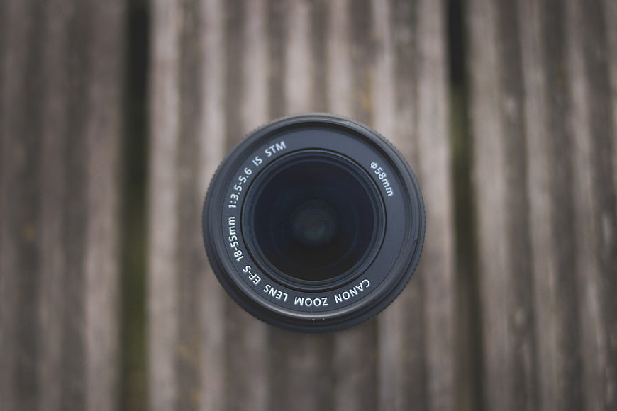 Overhead view of Canon camera lens on wooden background