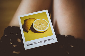 Polaroid of sliced lemon on woman's legs with inspirational quote