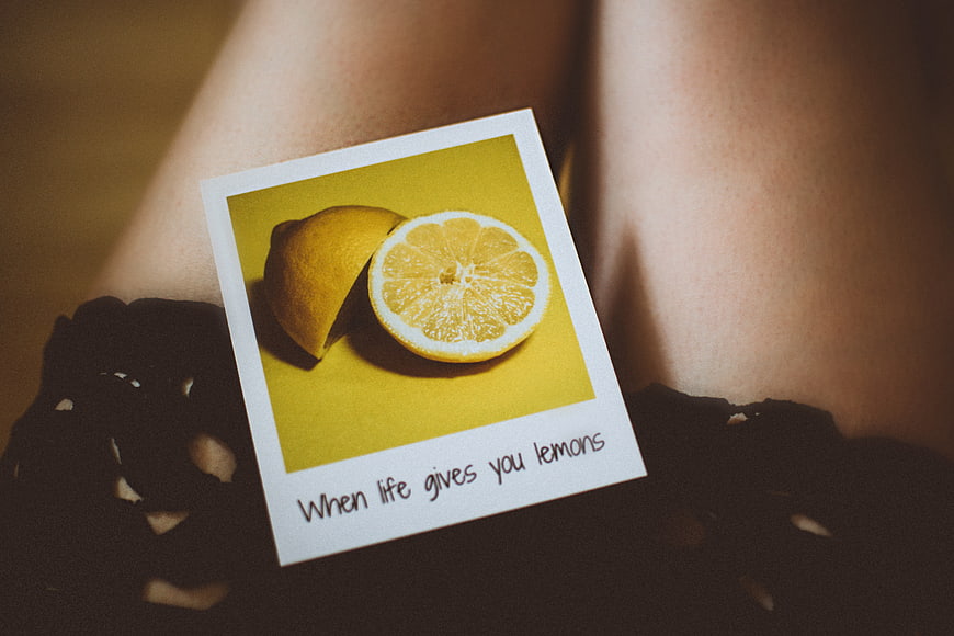Polaroid of sliced lemon on woman's legs with inspirational quote