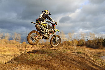 Motocross Rider Jumping Dirt Bike on Autumn Track