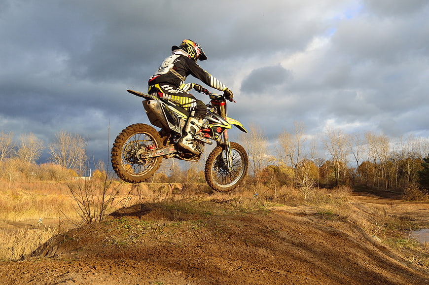 Motocross Rider Jumping Dirt Bike on Autumn Track
