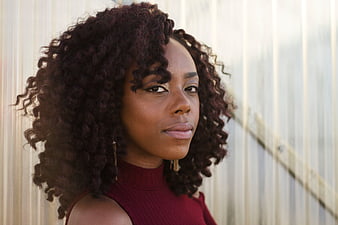 Portrait of Woman with Curly Hair Against Corrugated Wall