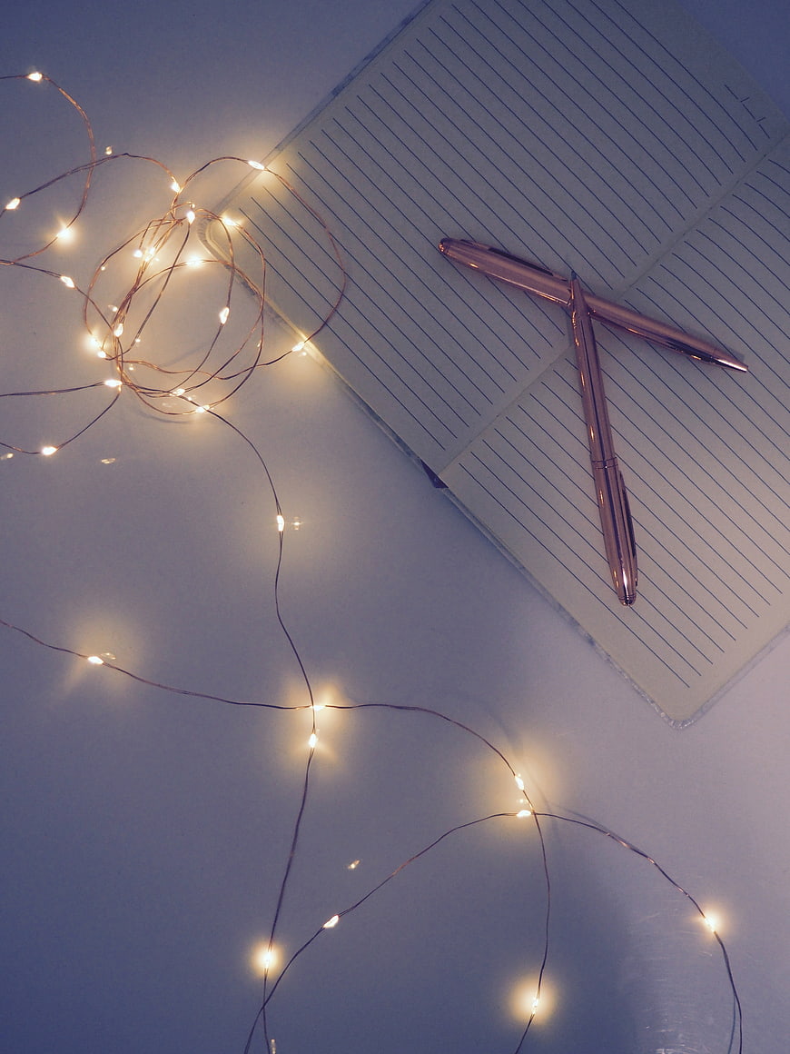 Rose Gold Pens on Notebook with Fairy Lights