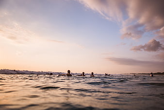 Surfers Waiting for Waves at Sunset Ocean