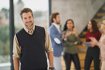 Smiling Businessman in Office with Colleagues